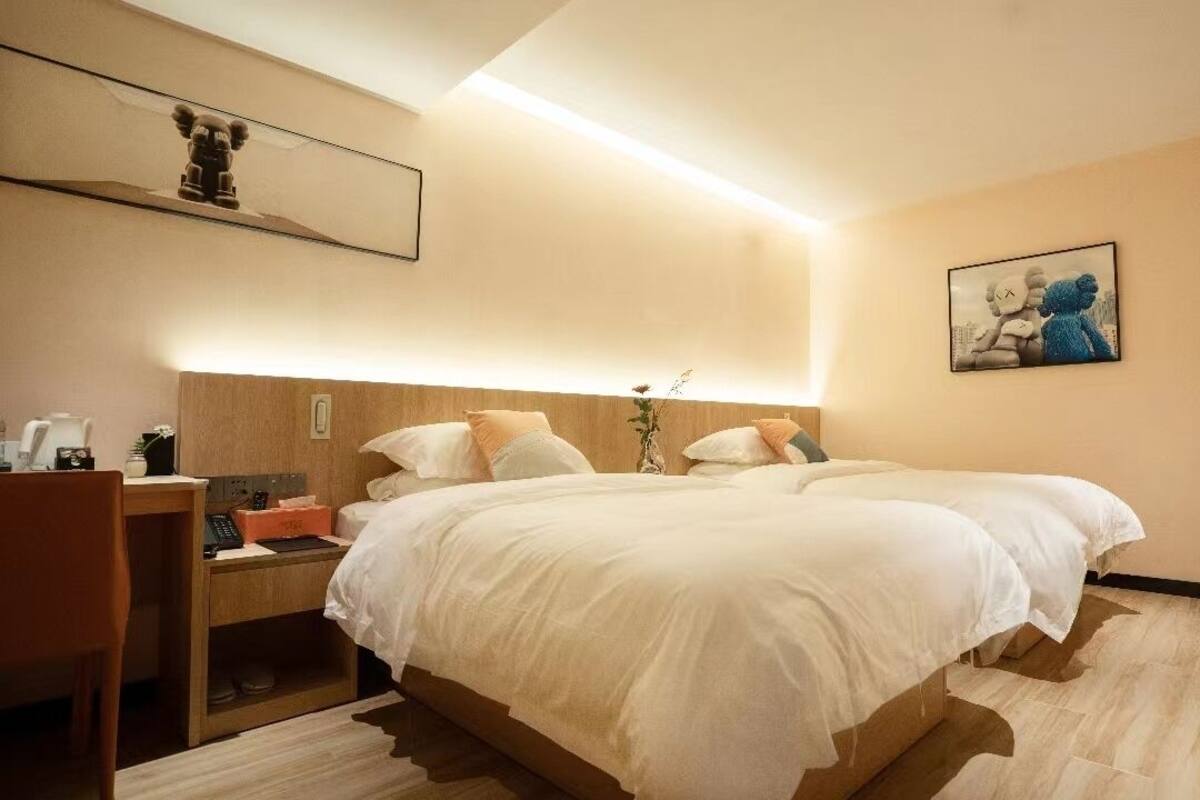Ein Hotelzimmer mit einem großen Bett, Nachttischen, einem Schreibtisch und einem Stuhl.
