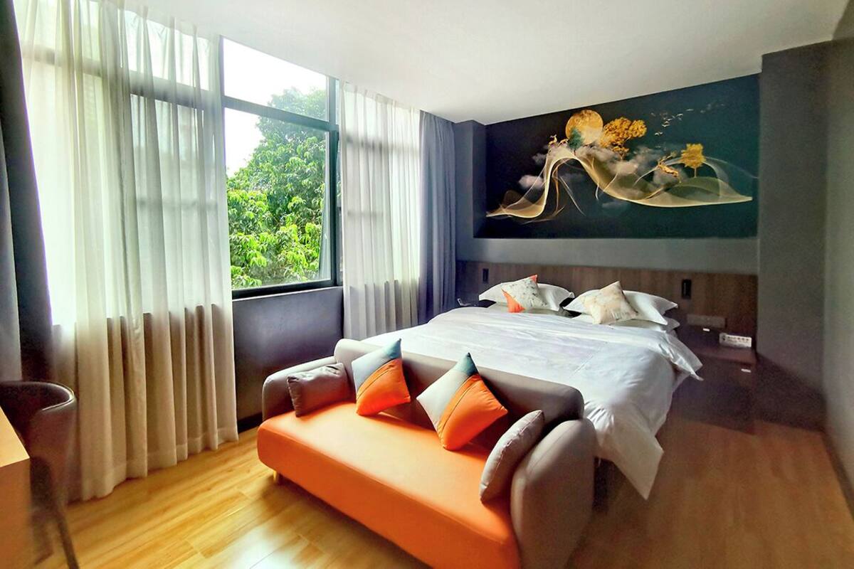 Ein modernes Hotelzimmer mit einem großen Bett, einer Sitzecke und einem Bild an der Wand.