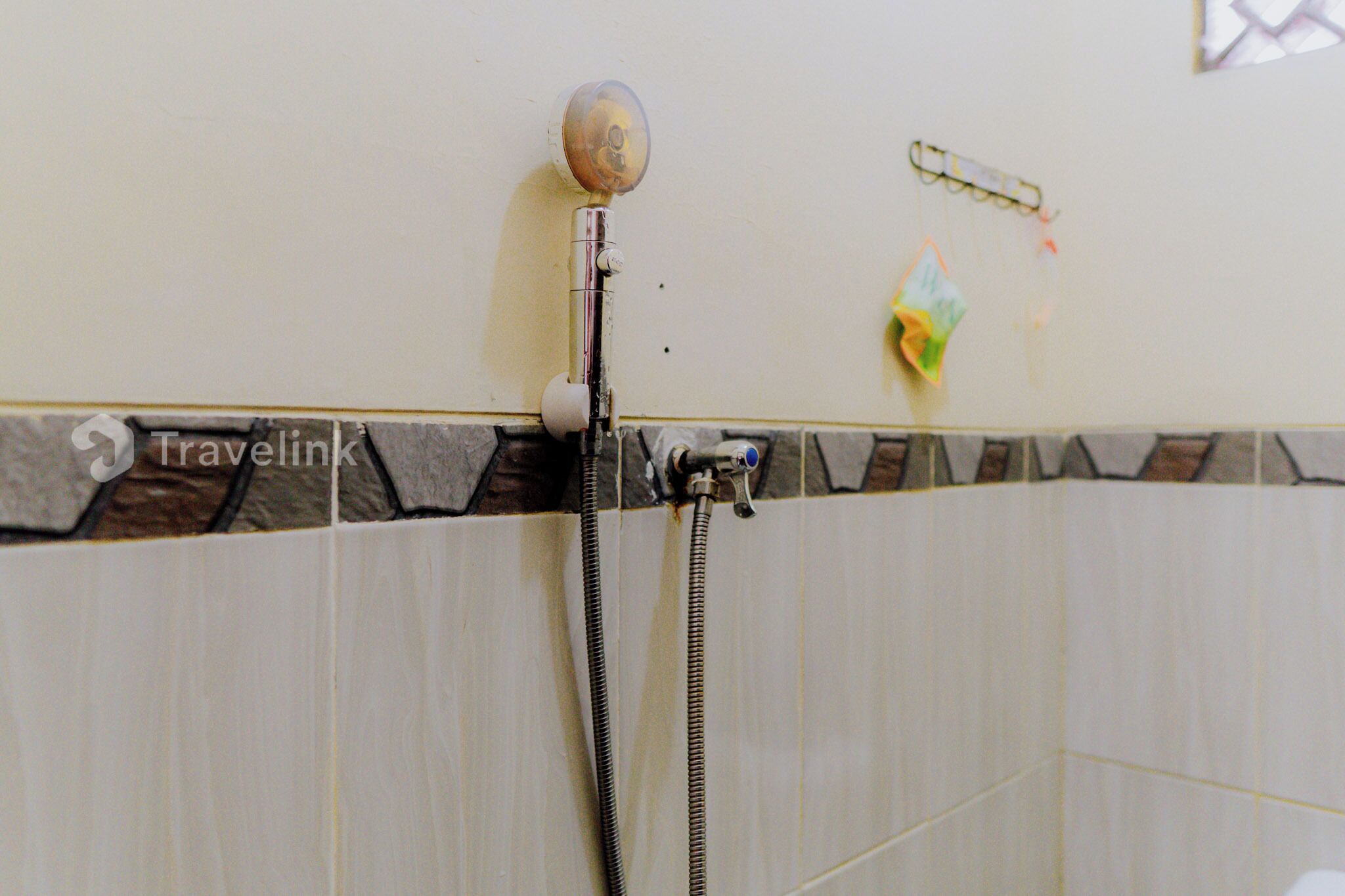 A shower with a handheld showerhead and a wall-mounted control valve.