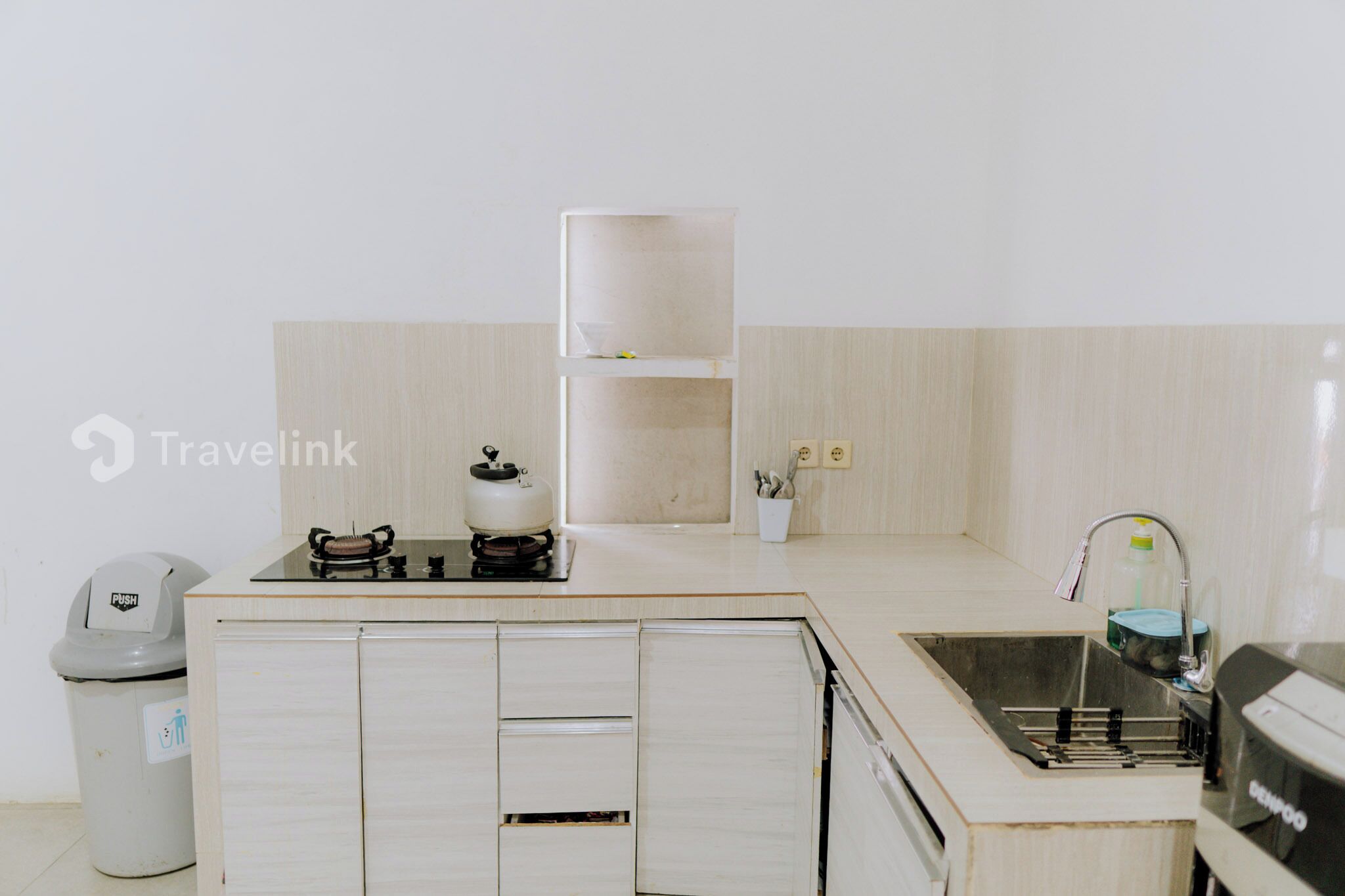 A small kitchenette with a stove, sink, and cabinets.