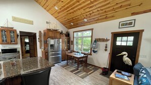 Une cuisine spacieuse avec des meubles en bois, un grand îlot central et un coin repas.