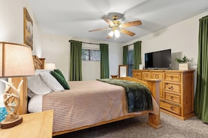 A bedroom with a bed, a wooden dresser, a television, and a ceiling fan. - Family Retreat - Balcony - Near White Sands - Wildlife - In Village (Cloudcroft)