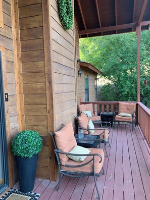 Eine Holzterrasse mit Sitzgelegenheiten und einem Blumentopf.