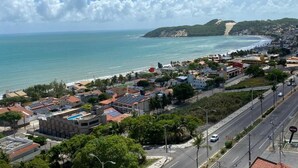 Un pueblo costero con playa, edificios y una carretera.