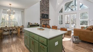 Una cocina amplia con una isla grande, armarios de madera y una pared decorativa de piedra.