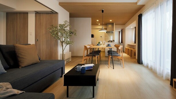 Una sala moderna con un sofá, una mesa de centro y un comedor con sillas y una mesa.