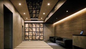 Un vestíbulo moderno con mostrador de recepción, zona de estar y pared con estampado.