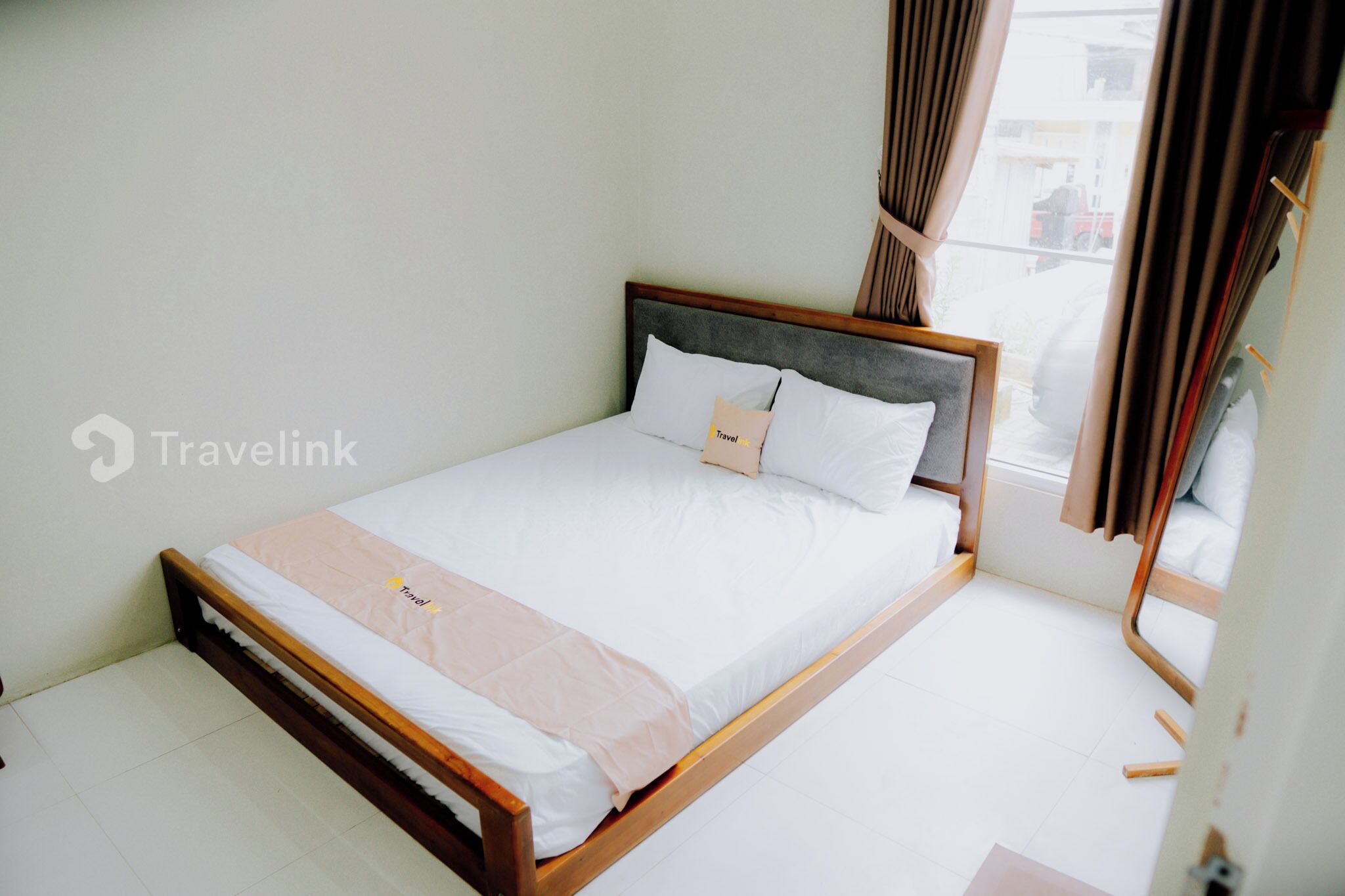 A single bed with a wooden frame, white bedding, and a headboard.