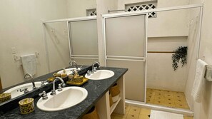 A bathroom with two sinks, a mirror, and a shower area. - Casa Zarah - Alma Hotels (Santa Marta)