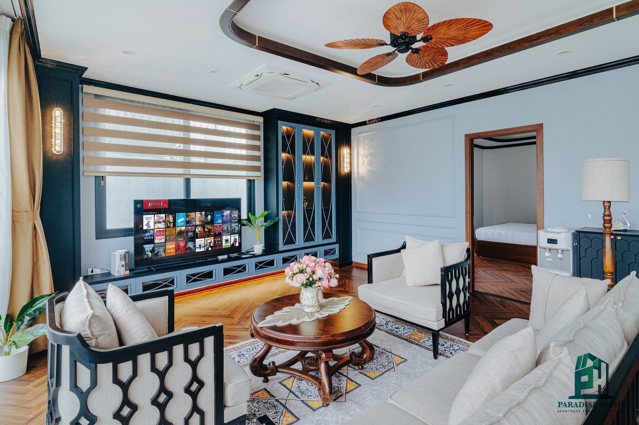A modern living room with a television, sofa, coffee table, and decorative items.
