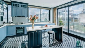 Una cocina moderna con armarios azules, un ventanal grande y piso a cuadros.