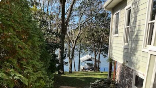 Un chemin de pierres qui mène à une maison dotée d’un petit jardin et offrant une vue sur un lac.