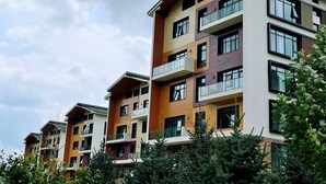 A multi-story residential building with balconies and large windows.