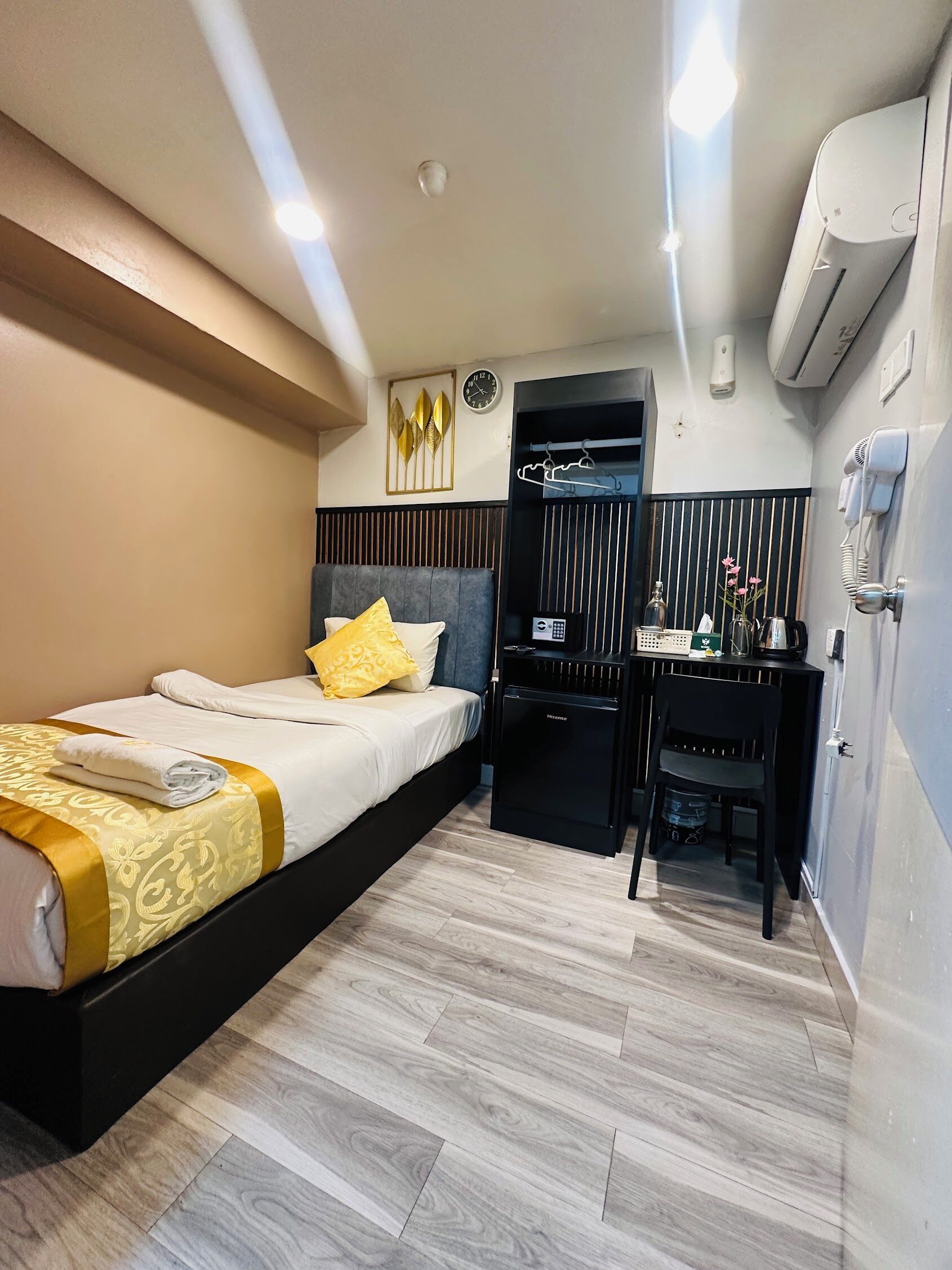 Ein Hotelzimmer mit Bett, Nachttisch, Schreibtisch, Stuhl und einer Minibar.