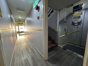 Stairs lead to a carpeted landing with a glass enclosure.