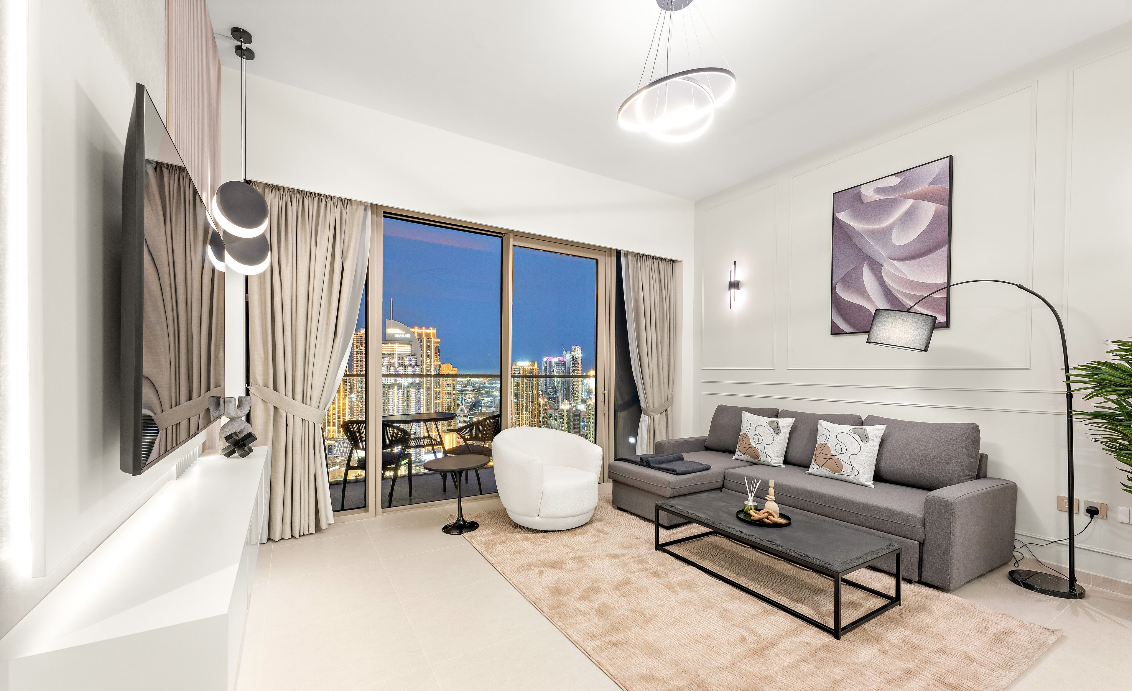 A modern living room with a city view, a sofa, a coffee table, and a floor lamp.