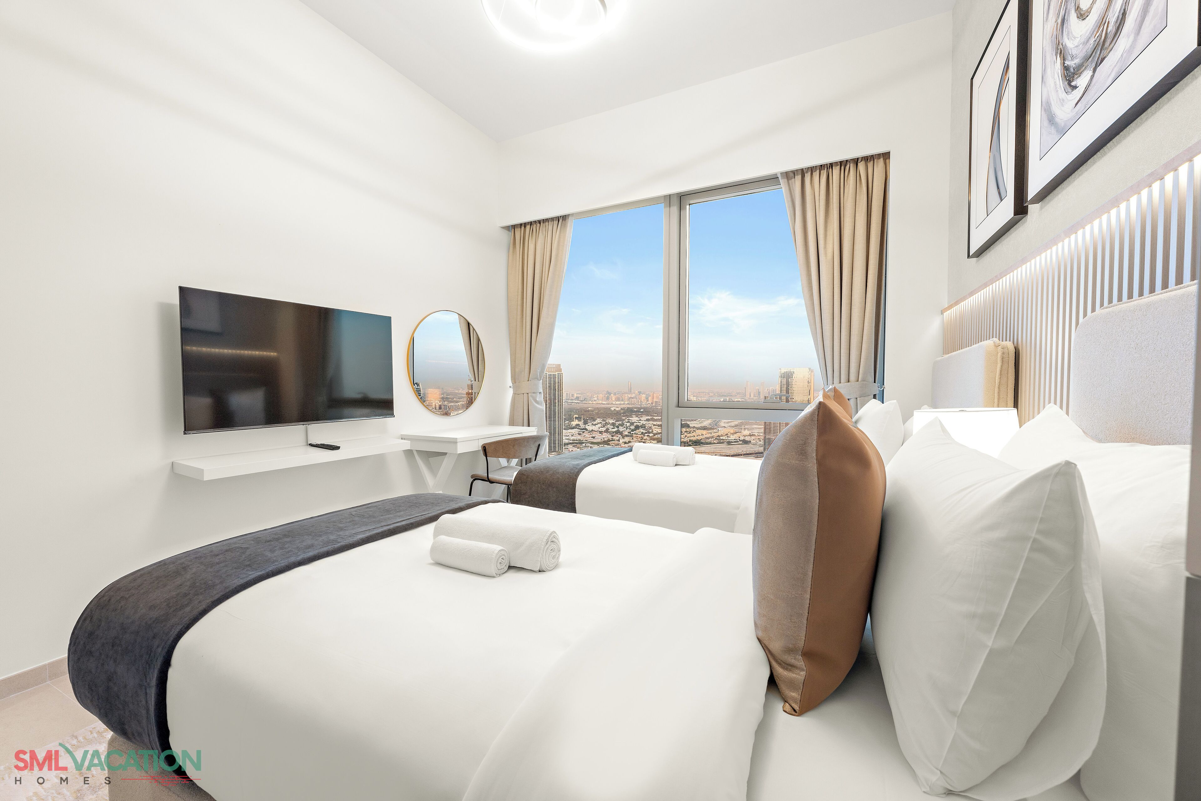 A modern hotel room with a large bed, a TV, a desk, and a city view.