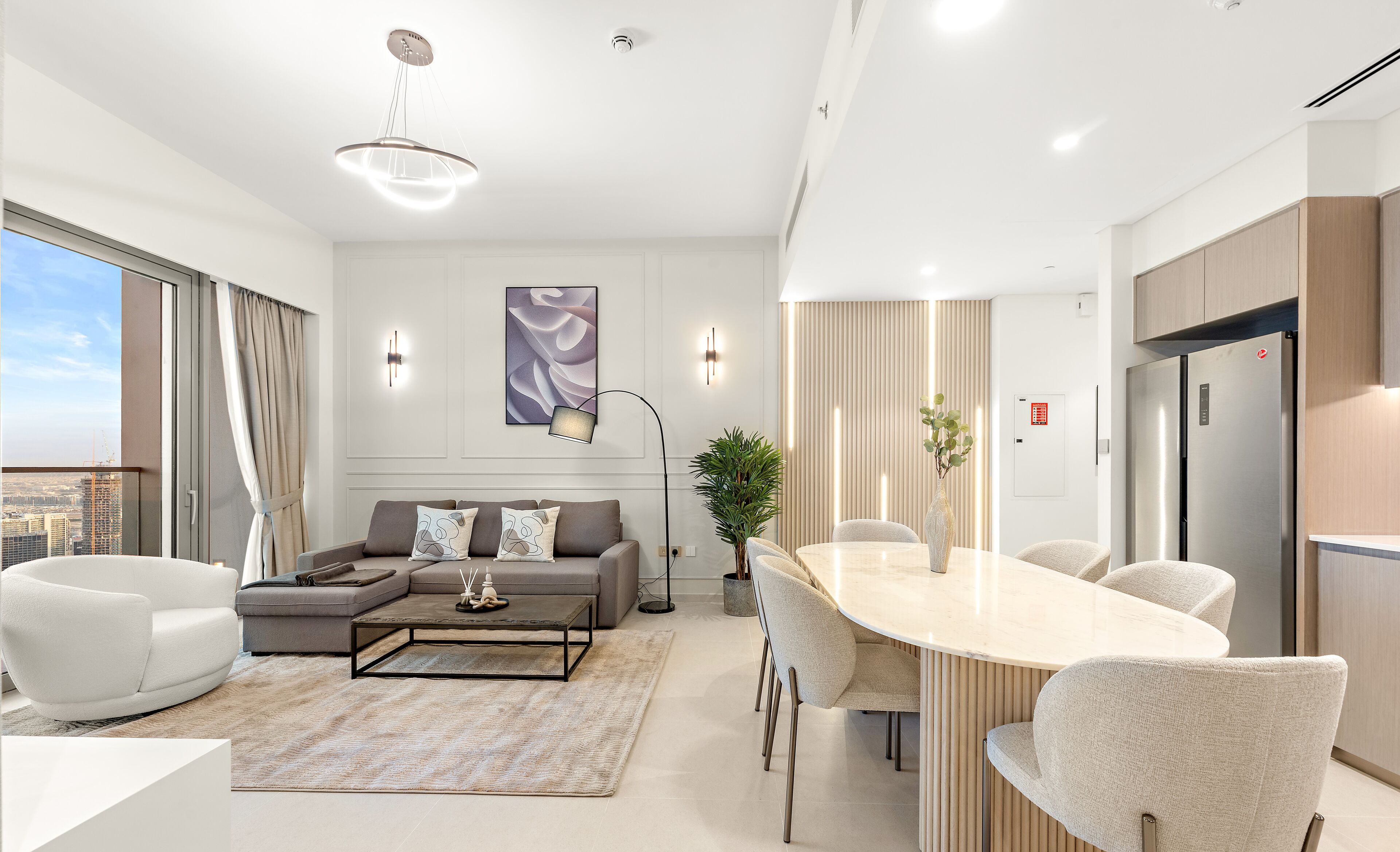A modern living room with a sofa, coffee table, and dining area.