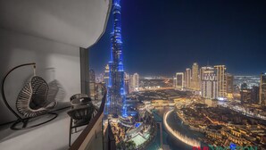 Un immeuble de grande hauteur doté d’un balcon incurvé, offrant une vue sur le paysage urbain illuminé la nuit.
