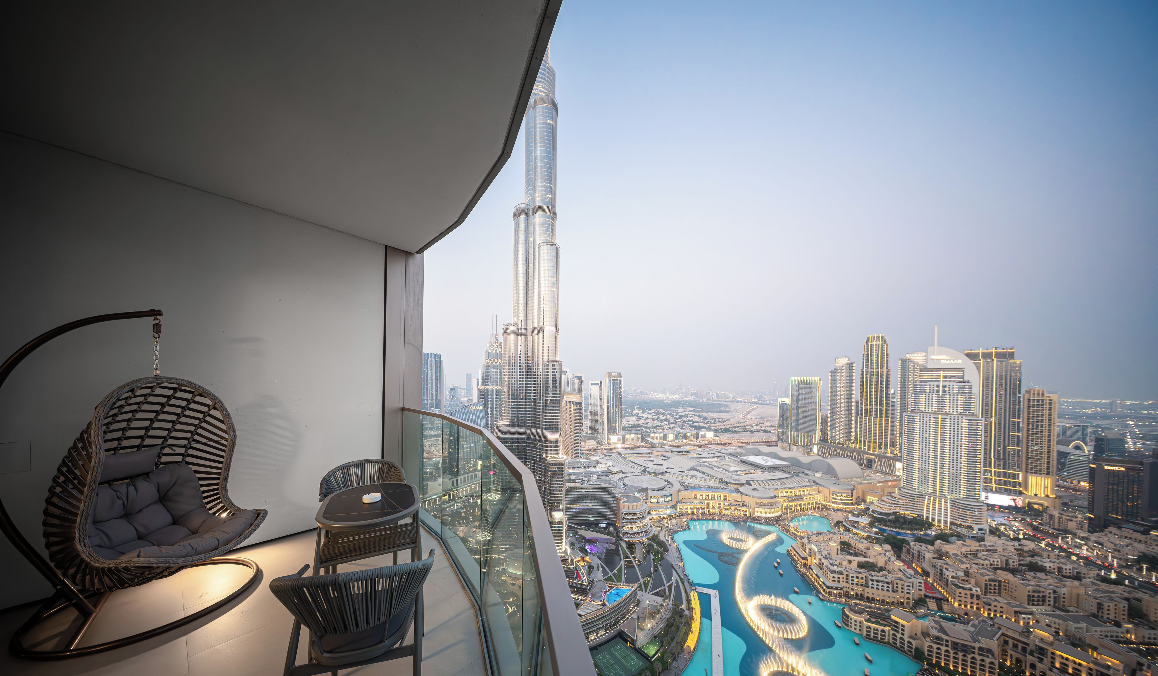 A balcony with a view of the Burj Khalifa and a pool area.