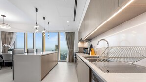 Une cuisine moderne dotée d’un îlot central, d’un évier intégré et offrant une vue sur la ville.