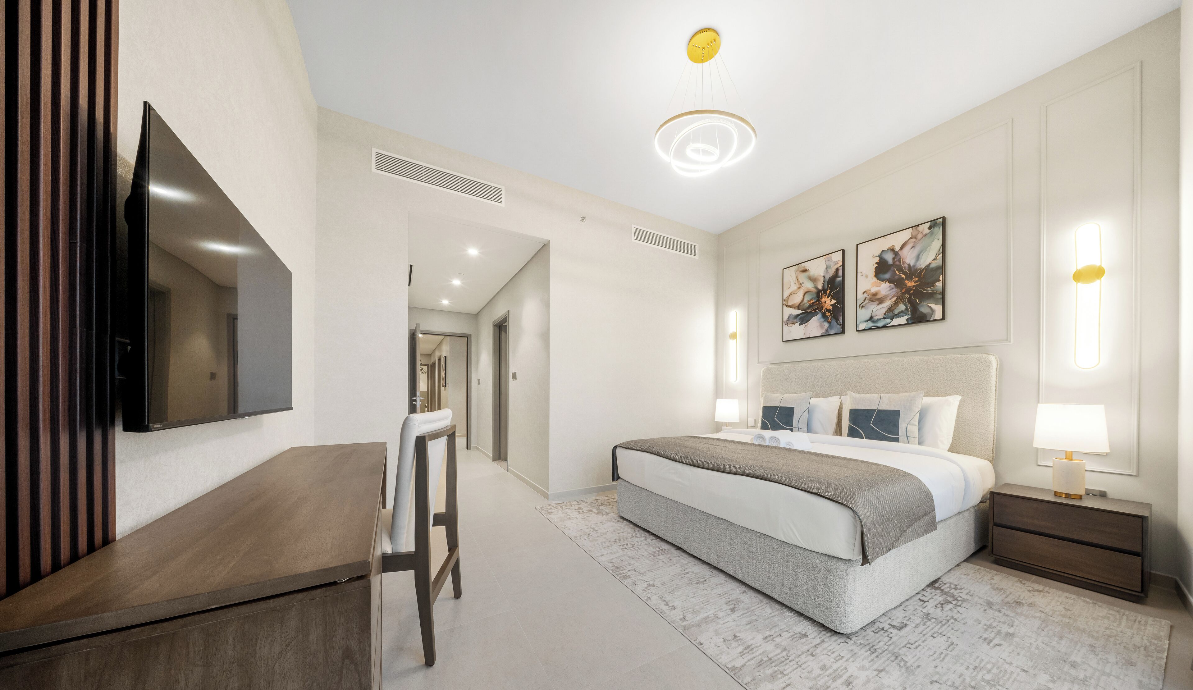 Une chambre d’hôtel moderne équipée d’un grand lit, d’un bureau et d’un téléviseur à écran plat.