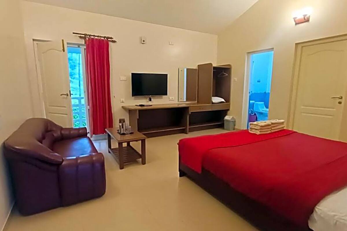 Una habitación de hotel con cama, sofá, escritorio y televisor.