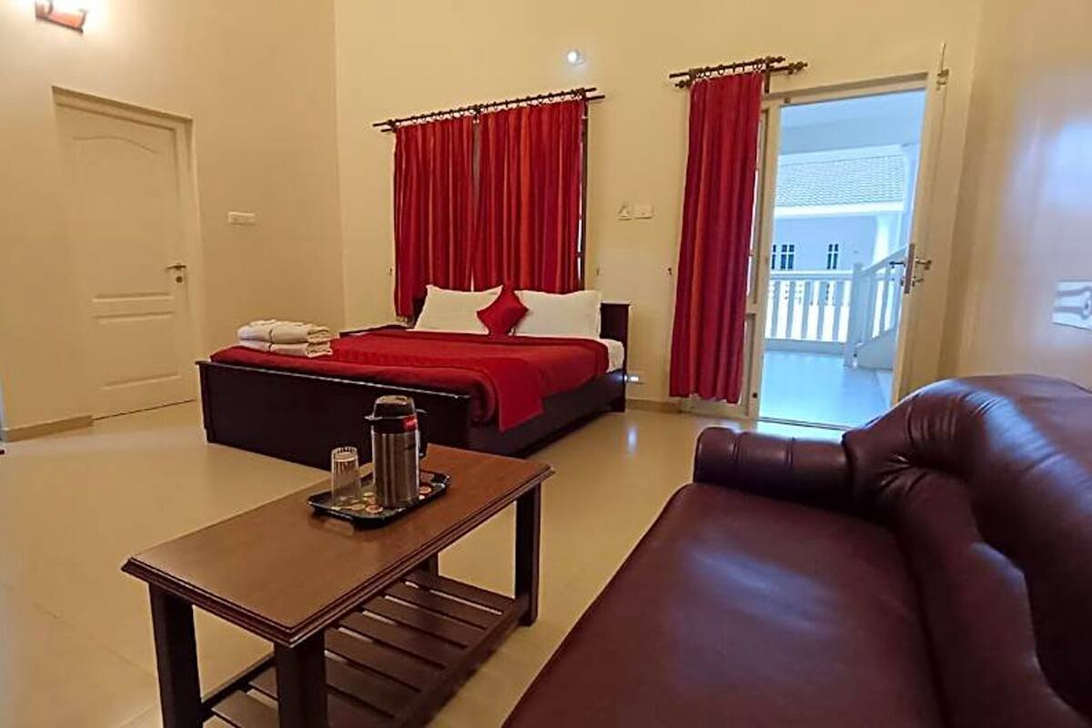 Una habitación de hotel con una cama, una mesa de centro, un sofá de cuero y vistas al exterior.