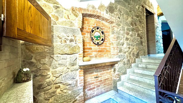 A stone wall with a fireplace and a decorative plate. - " Village Center Apartments - Apt 1 - 2 " (Bari Sardo)