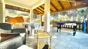 An outdoor patio with wicker furniture, a pool table, and a covered area with a table and chairs. - "  Sea  Breeze  Home " (Lotzorai)