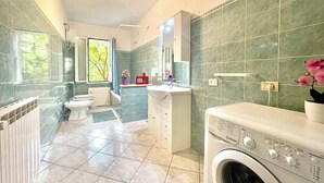 Ein modernes Badezimmer mit Waschmaschine, Toilette und Waschbecken.