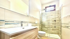 A modern bathroom with a glass shower enclosure, a white sink, and a toilet. - " Beach House with Terrace " (Bari Sardo)