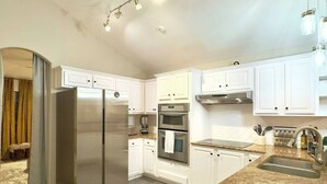 A modern kitchen with white cabinetry, stainless steel appliances, and a granite countertop. - Spacious Family Gem, Close to Lake, Hot Tub (Lago Vista)