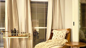 A bedroom with a wooden bed, a small wooden table, a glass cabinet with kitchen items, and a patterned rug. - Spacious Family Gem, Close to Lake, Hot Tub (Lago Vista)