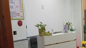 Egy recepciós pult, amelyen egy tábla jelzi: „TRÔ TIem Hotel & Spa”.