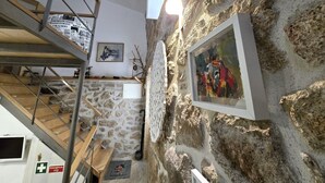 A staircase with a stone wall and a framed painting.