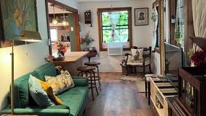 Una sala de estar acogedora con un sofá verde, una mesa de centro de madera y una radio antigua.