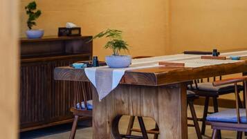 Una mesa de madera con un mantel blanco, una planta en maceta y un teclado.