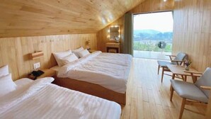 A wooden cabin bedroom with two beds, a desk, and a chair. - La Maison Dalat (Lang Biang - Da Lat)