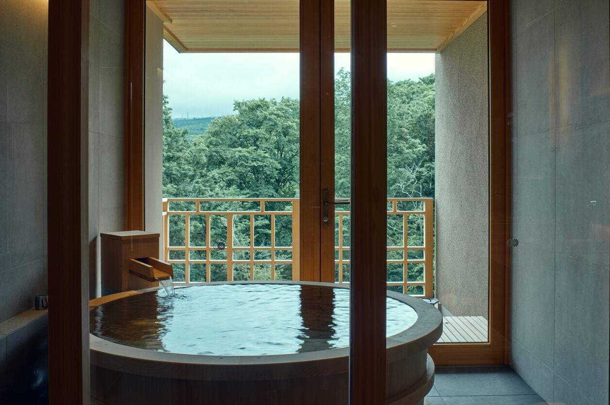 Un jacuzzi con vista a un balcón y árboles.