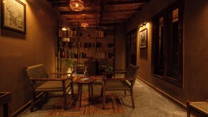 Un rincón acogedor para leer, con una estantería, dos sillones y una mesita.