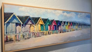 Una pintura de cabañas de playa coloridas en fila.