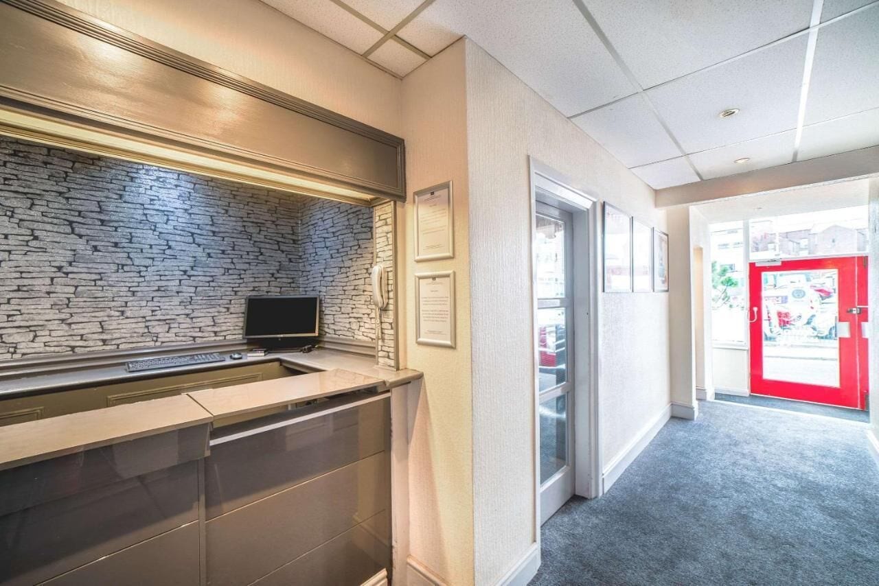 A reception area with a stone wall, a flat-screen TV, a counter, and framed certificates on the wall.