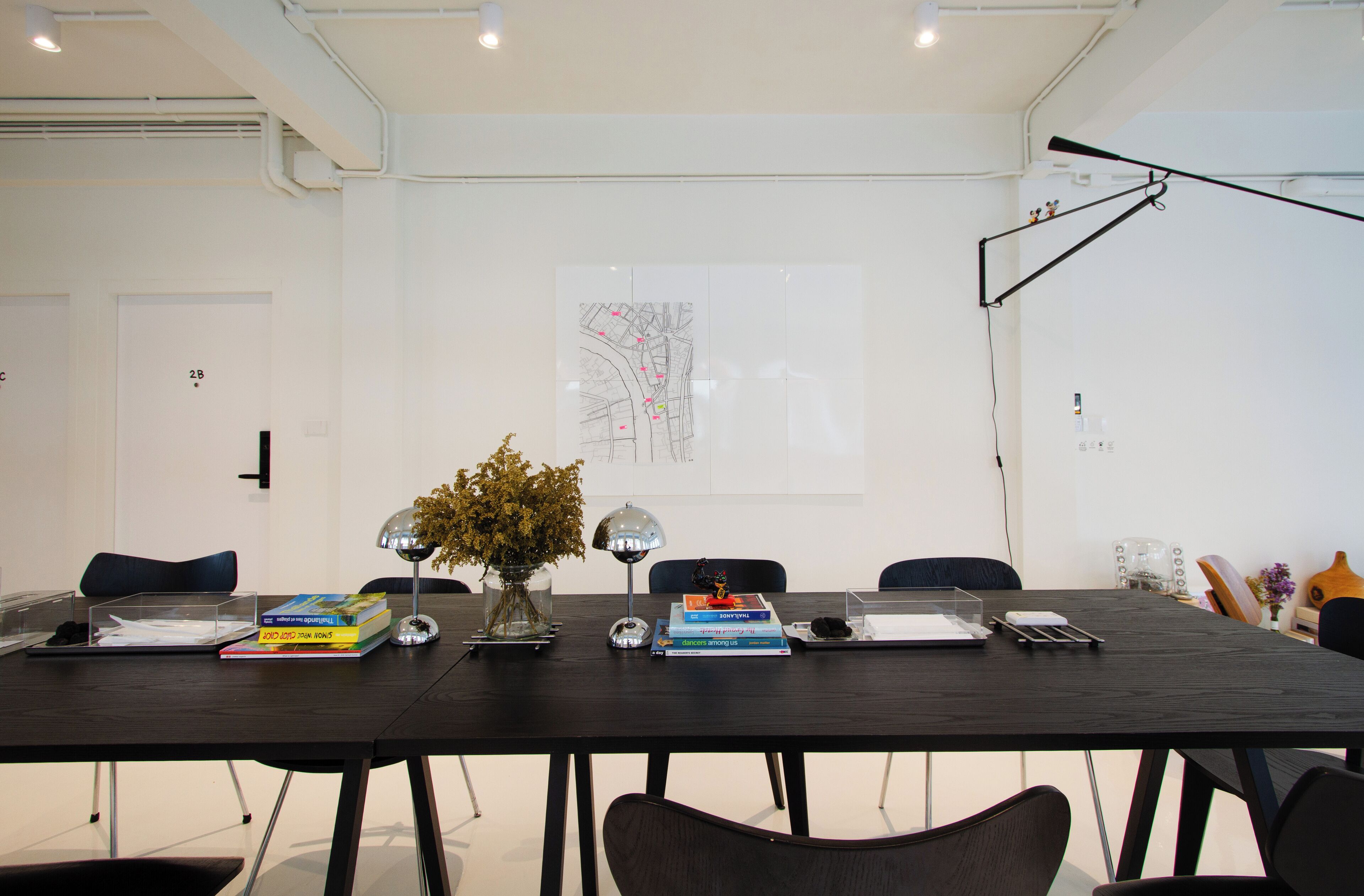 A conference room with a long table, chairs, a map on the wall, and various office supplies.