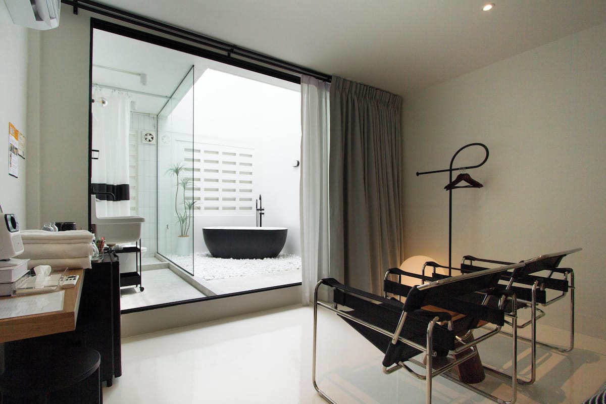 Une salle de bain moderne avec un grand miroir, une baignoire et un espace douche.