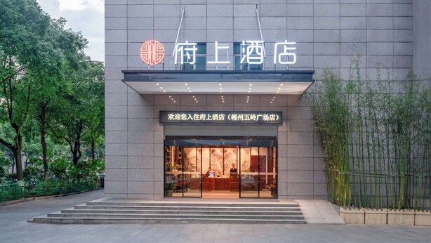L’entrée d’un hôtel, avec une façade moderne, une enseigne bien visible et un espace d’accueil chaleureux.