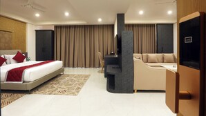 Ein modernes Hotelzimmer mit Bett, einer Couch, einem Schreibtisch und einem Fernseher.