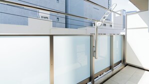 En modern byggnad med en fasad av glas, metallräcken och fri utsikt mot himlen.