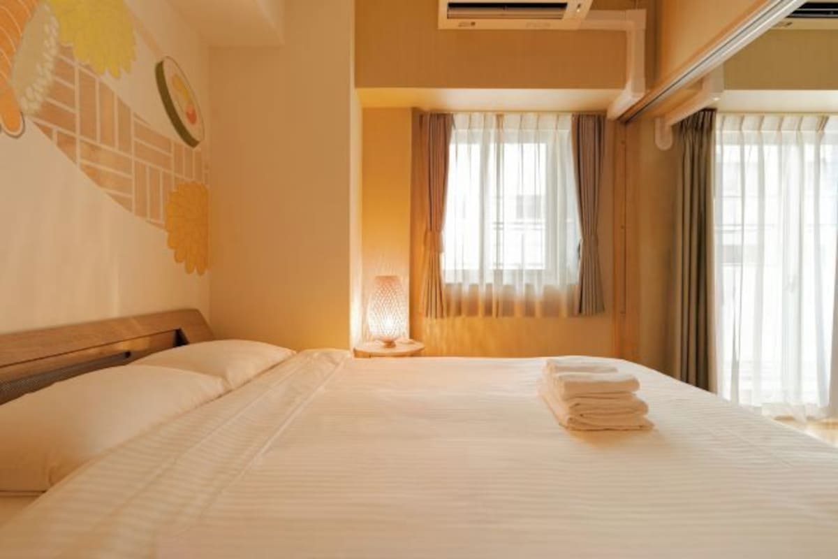 Ein Hotelzimmer mit Bett, Lampe und einem fenster mit Vorhängen.