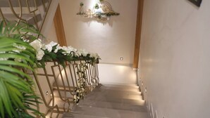 A staircase with a decorative railing and a hanging light fixture. - The Meera Hotel (Ujjain)